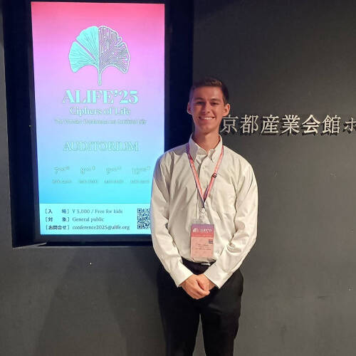Marcos standing by a conference sign